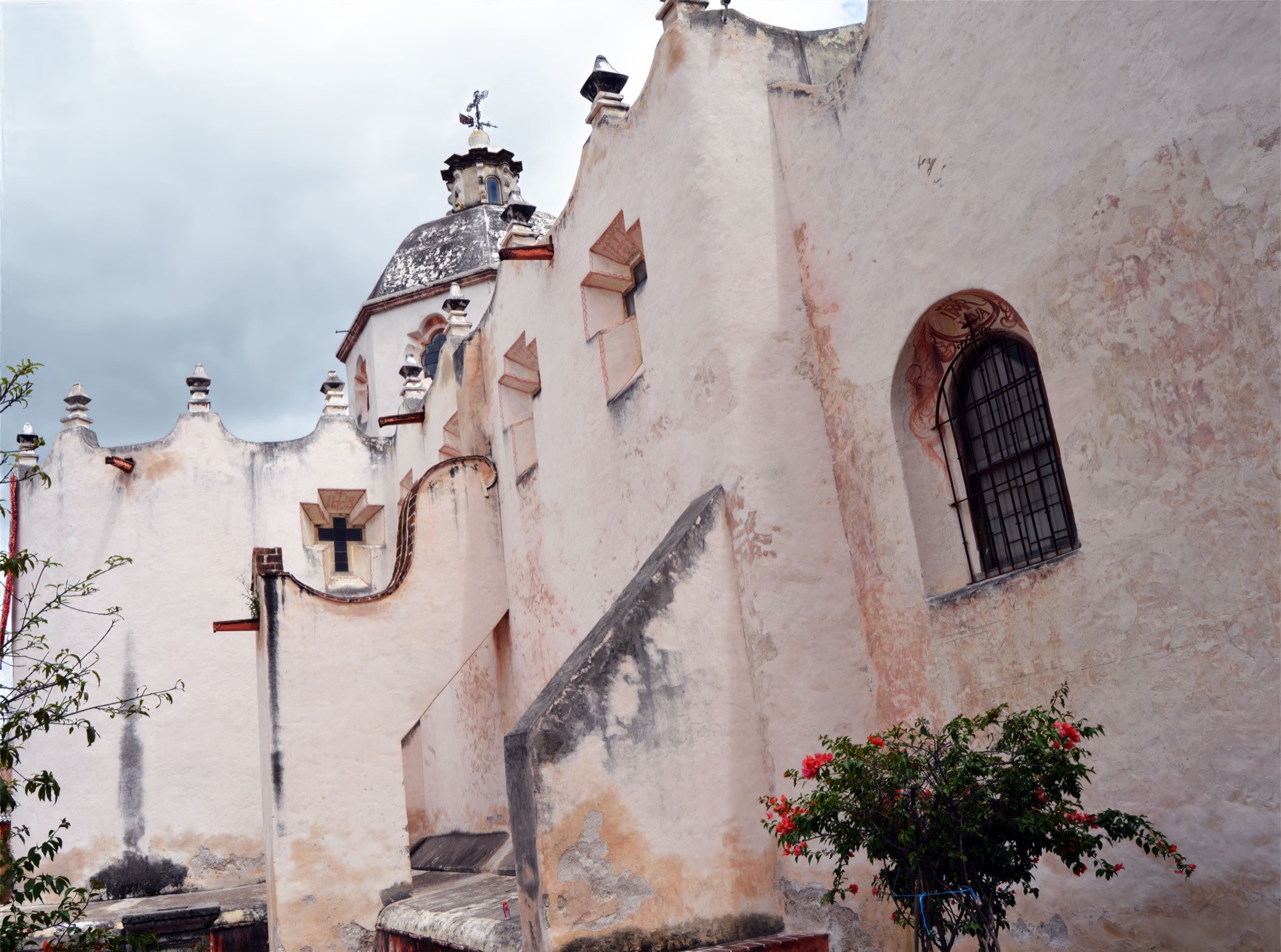 The softly weathered rose-toned walls and curved roofline of Atotonilco sanctuary